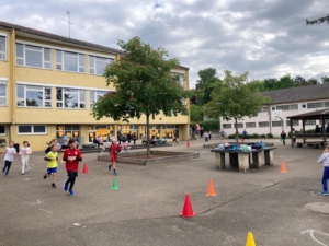 Kinder laufen für den Spendenlauf auf dem Schulhof